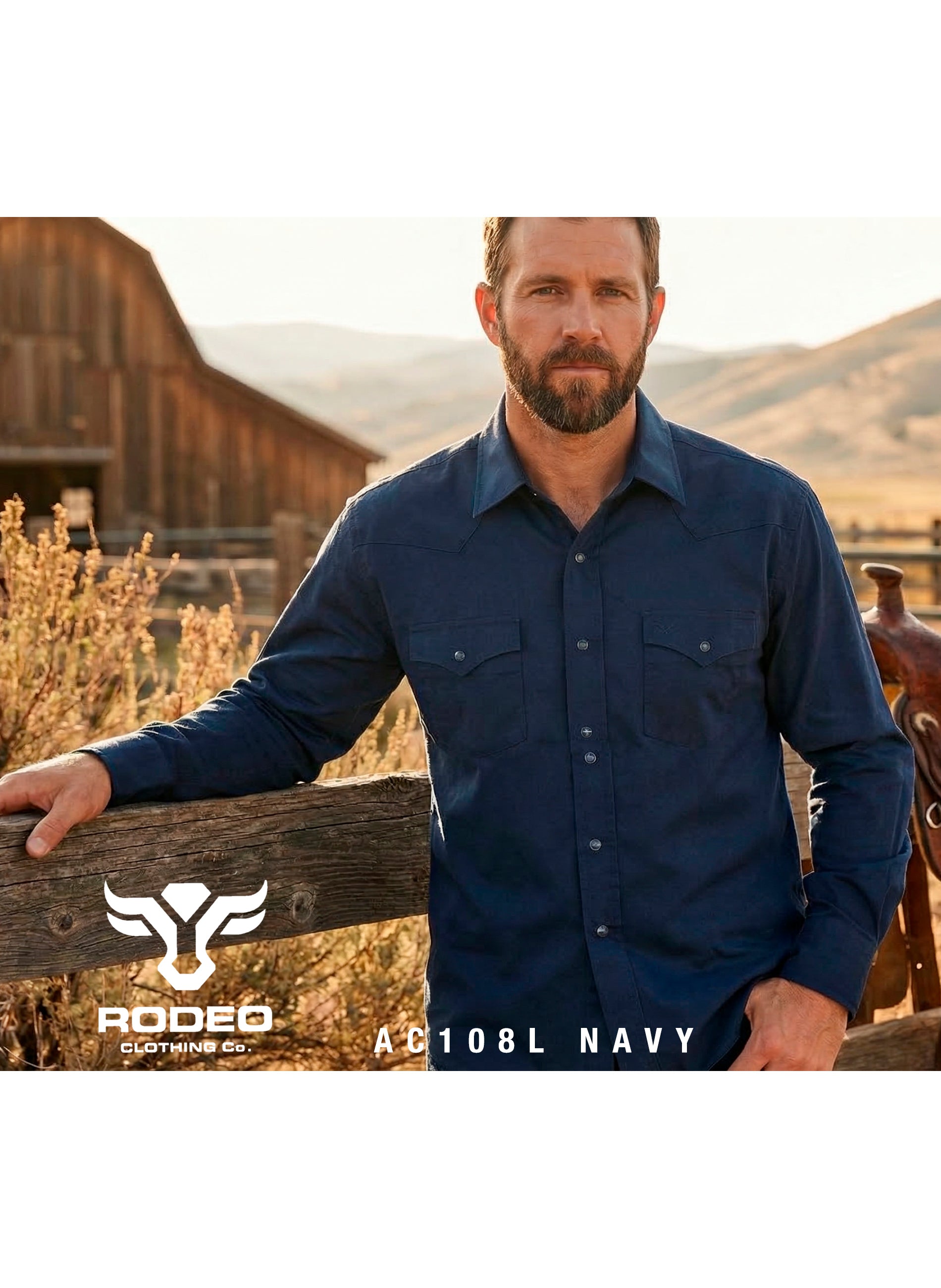 Man wearing a navy shirt standing in front of a wooden fence with a scenic background